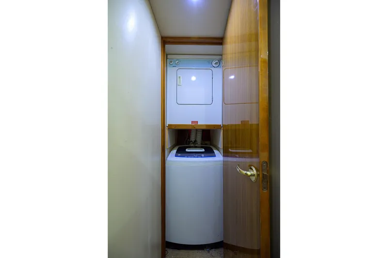 Slide: The Image of Compact laundry area with stacked washer and dryer in a 2005 Viking 61 yacht. - 23