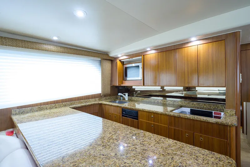 Slide: The Image of Luxurious kitchen interior of 2005 Viking 61 yacht with granite countertops and wooden cabinetry. - 27