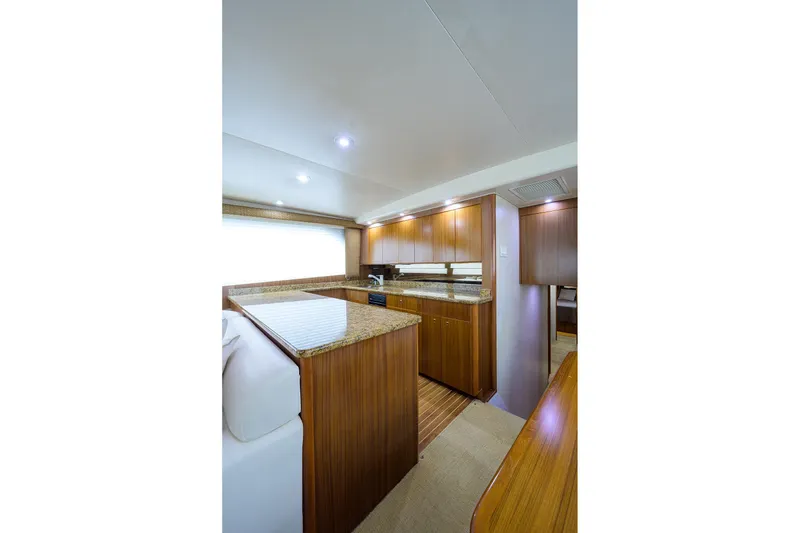 Slide: The Image of Luxurious 2005 Viking 61 yacht interior with elegant wood cabinetry and granite countertops. - 29