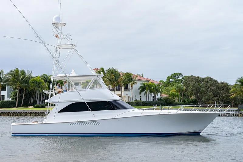 Slide: The Image of 2005 Viking 61 yacht cruising near waterfront homes with palm trees. - 3