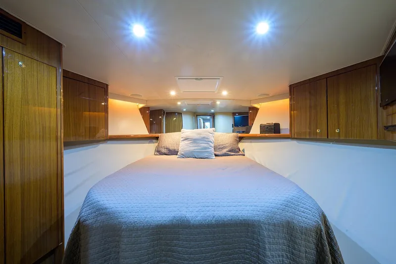 Slide: The Image of Luxurious cabin interior of a 2005 Viking 61 yacht with cozy bedding and wooden cabinetry. - 36