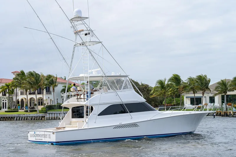 Slide: The Image of 2005 Viking 61 yacht cruising near waterfront homes with palm trees. - 4