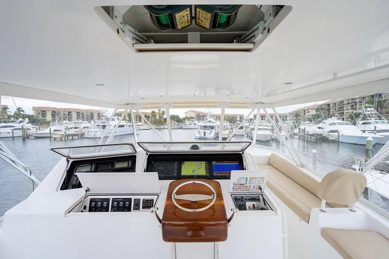 Slide: The Image of 2005 Viking 61 yacht helm with navigation controls, overlooking marina with docked boats. - 43