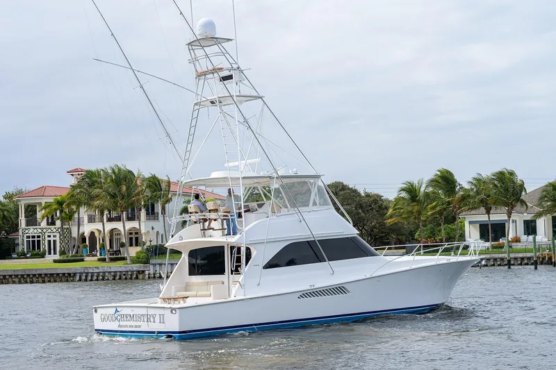Slide: The Image of 2005 Viking 61 yacht cruising near waterfront homes with palm trees. - 5