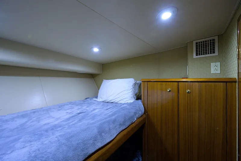 Slide: The Image of Cozy cabin interior of 2005 Viking 61 yacht with bed and wooden cabinet. - 54