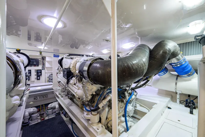 Slide: The Image of Engine room of a 2005 Viking 61 yacht, showcasing complex machinery and piping. - 56