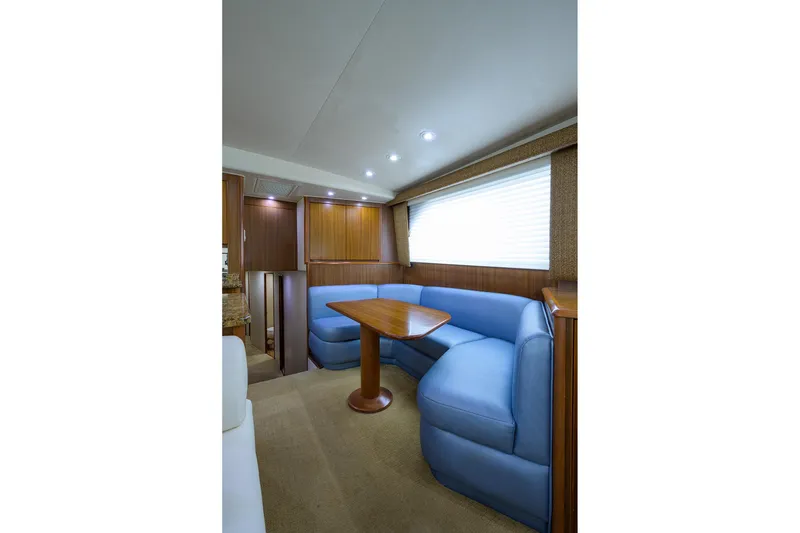 Slide: The Image of Interior of 2005 Viking 61 yacht with blue seating and wooden table. - 57