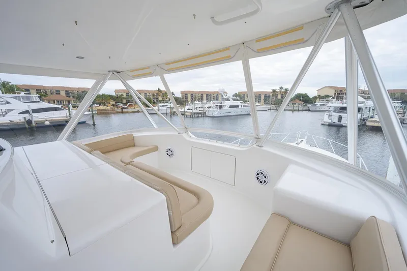 Slide: The Image of Luxurious 2005 Viking 61 yacht interior with beige seating, overlooking marina. - 58
