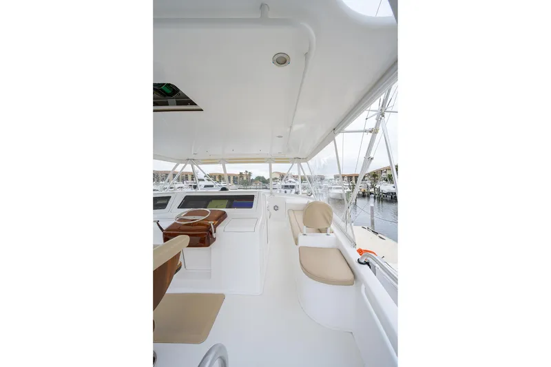 Slide: The Image of 2005 Viking 61 yacht helm with beige seating and marina view. - 59