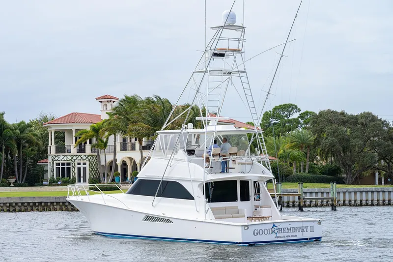 Slide: The Image of 2005 Viking 61 yacht cruising near luxury waterfront property. - 7