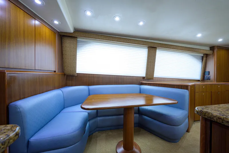 Slide: The Image of Luxurious 2005 Viking 61 yacht interior with blue seating and wooden table. - 76