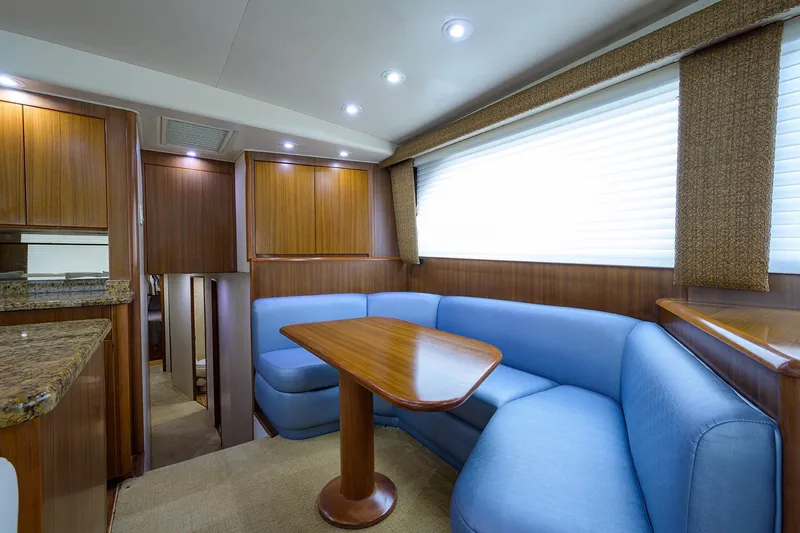 Slide: The Image of Luxurious interior of 2005 Viking 61 yacht with blue seating and wooden accents. - 77