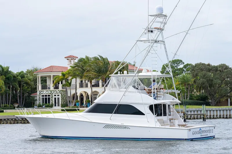 Slide: The Image of 2005 Viking 61 yacht cruising near luxury waterfront property. - 8