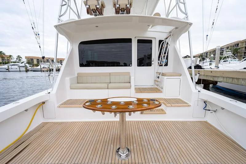 Slide: The Image of 2005 Viking 61 yacht deck with seating and fishing rod holders, docked at marina. - 83
