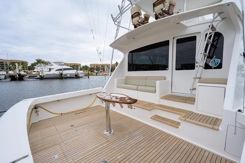 Slide: The Image of 2005 Viking 61 yacht deck with seating, table, and marina view. - 84