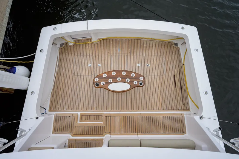 Slide: The Image of 2005 Viking 61 yacht deck with teak flooring and fishing rod holders. - 88