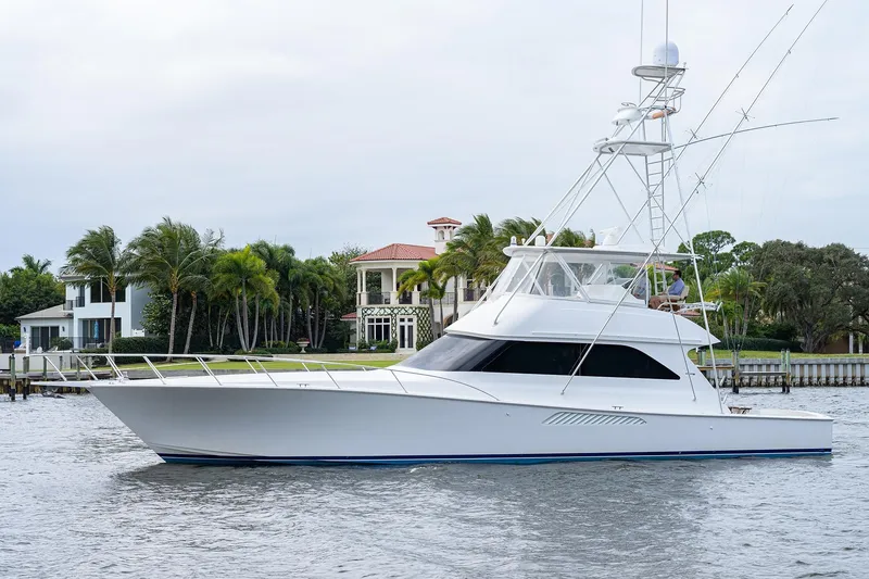 Slide: The Image of 2005 Viking 61 yacht cruising near waterfront homes with palm trees. - 9
