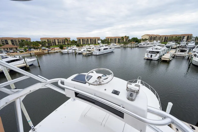 Slide: The Image of View from 2005 Viking 61 yacht helm overlooking marina with docked boats and waterfront buildings. - 91