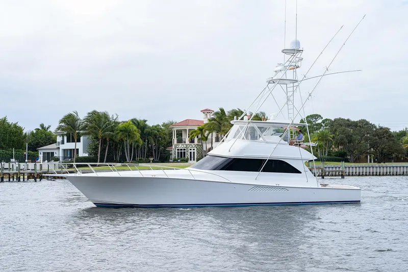 Slide: The Image of 2005 Viking 61 yacht cruising near waterfront homes with palm trees. - 98