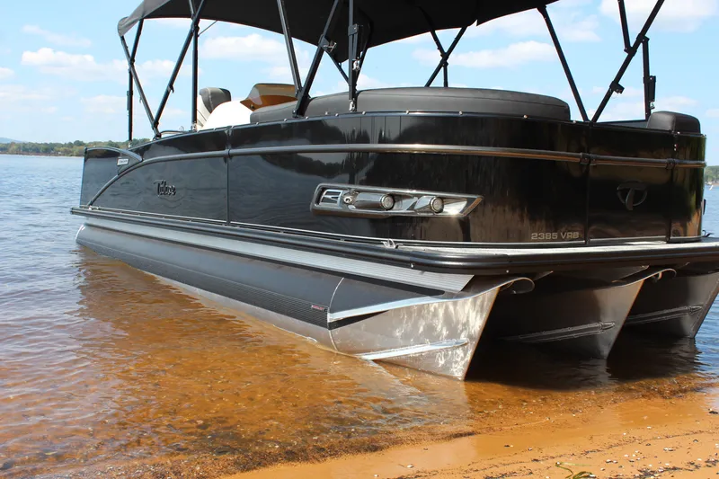 The Image of 2023 Tahoe Pontoon Cascade Platinum Versatile Rear Bench 23' on a sandy shore. - 1