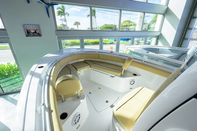 The Image of 2026 Sportsman Open 232 Center Console boat interior with beige seating in a showroom. - 0