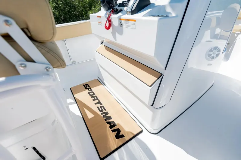 Slide: The Image of 2026 Sportsman Open 232 Center Console boat interior in showroom with mounted engines. - 11