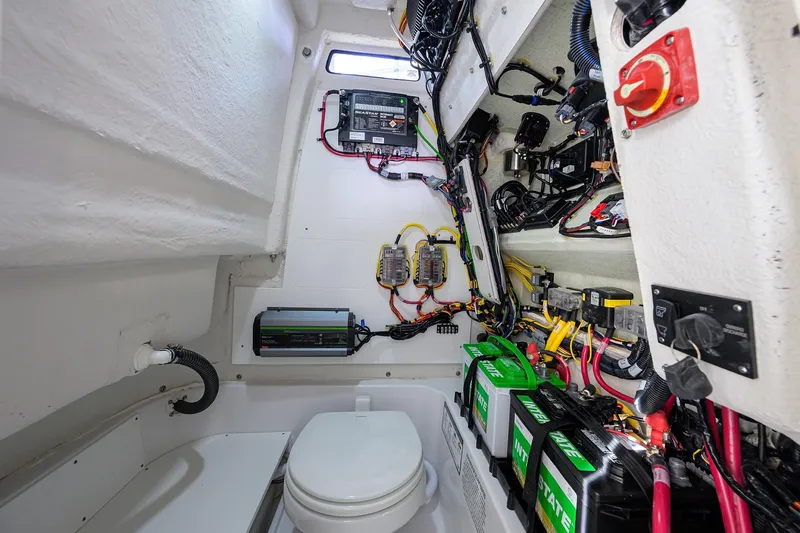 Slide: The Image of Interior of 2026 Sportsman Open 232 Center Console showing electrical wiring and marine battery setup. - 17