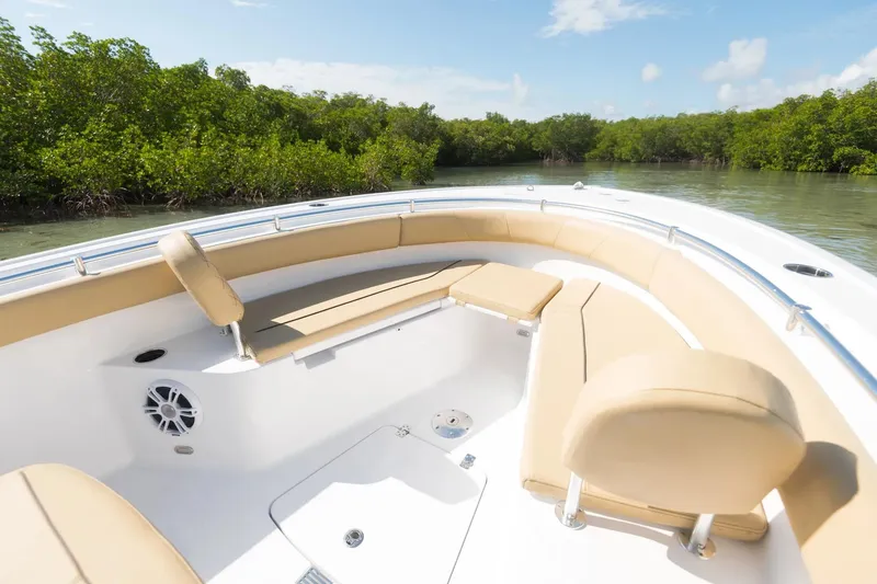 Slide: The Image of 2026 Sportsman Open 232 Center Console boat interior with beige seating in showroom. - 2