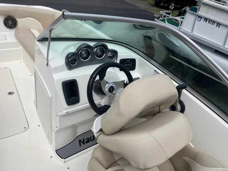 Slide: The Image of 2016 NauticStar 203DC Sport Deck boat interior with steering wheel and dashboard. - 10
