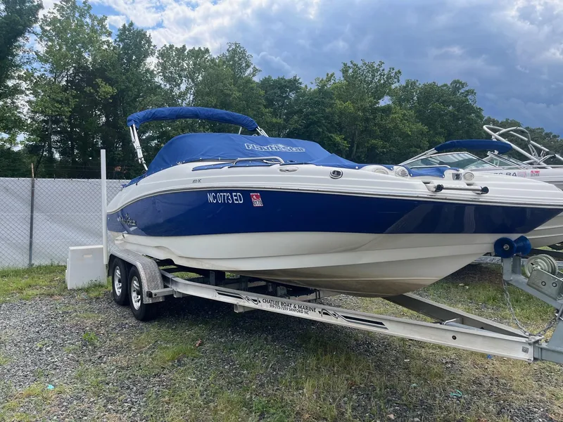 Slide: The Image of 2016 NauticStar 203DC Sport Deck boat on trailer, blue and white, parked outdoors. - 3