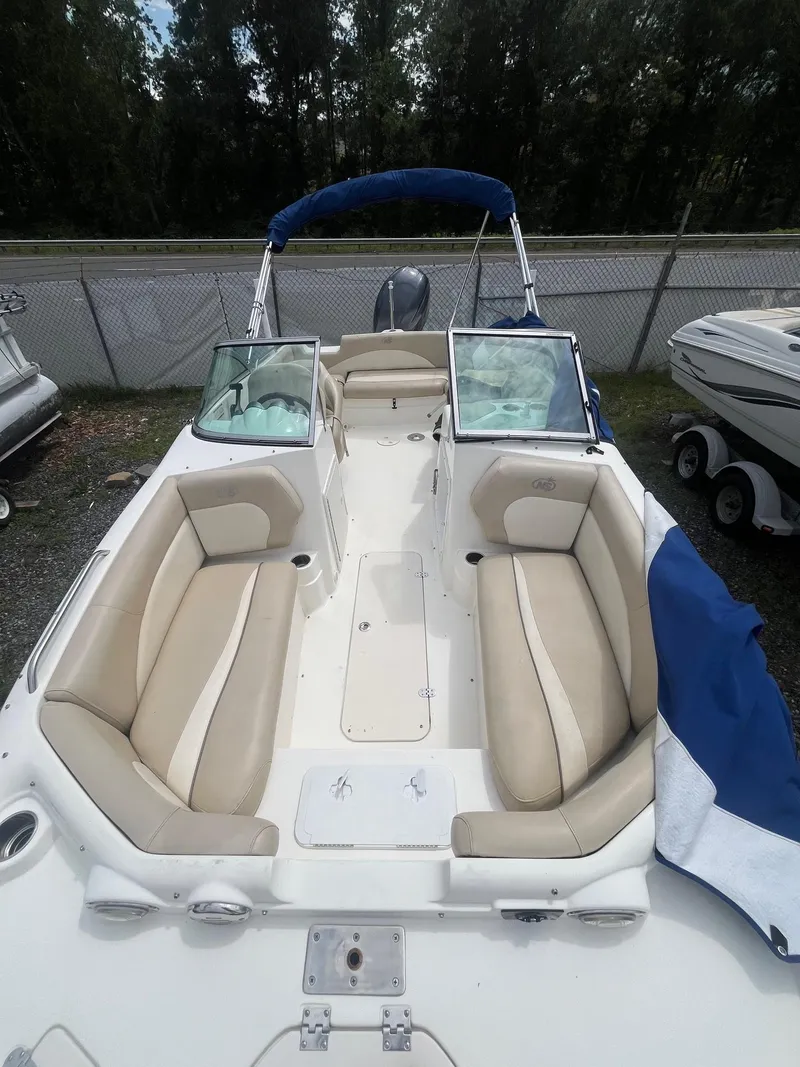 Slide: The Image of 2016 NauticStar 203DC Sport Deck boat with beige seating and blue canopy. - 5