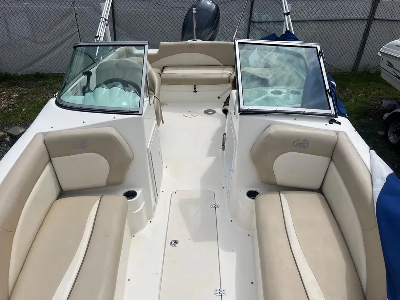 Slide: The Image of 2016 NauticStar 203DC Sport Deck boat with beige seating and open deck layout. - 6