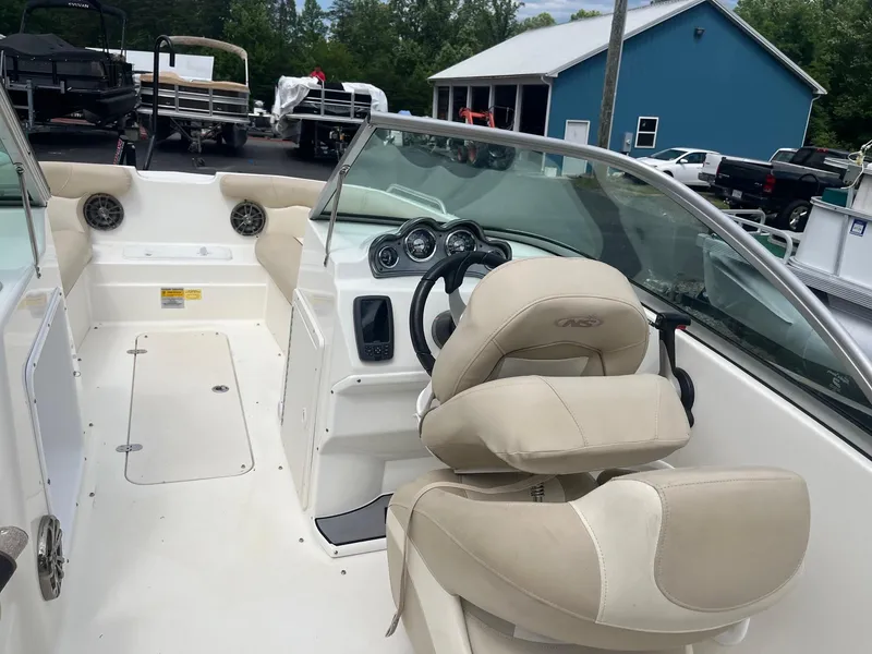 Slide: The Image of 2016 NauticStar 203DC Sport Deck boat interior with beige seating and dashboard. - 9