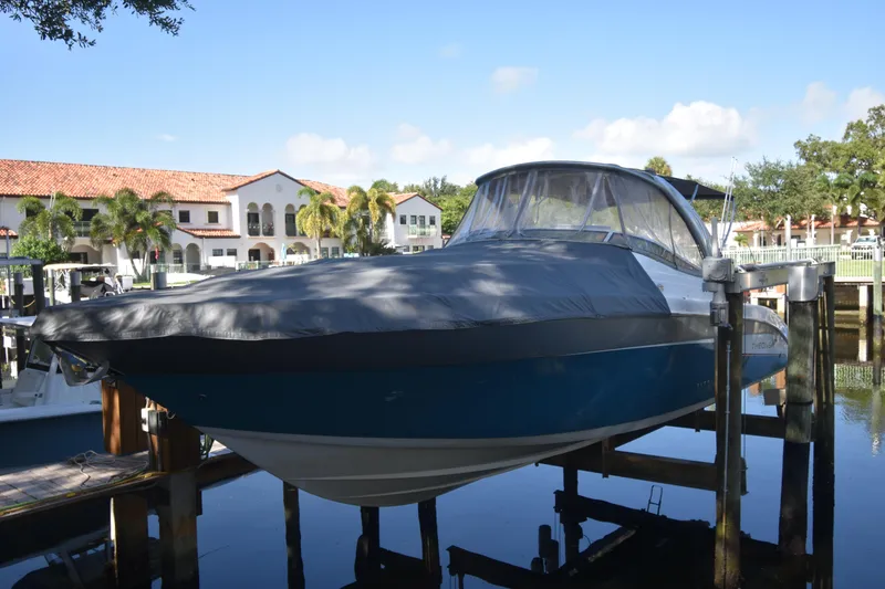 Slide: The Image of 2018 Pronautica 34 boat docked, covered, in a scenic marina setting. - 2