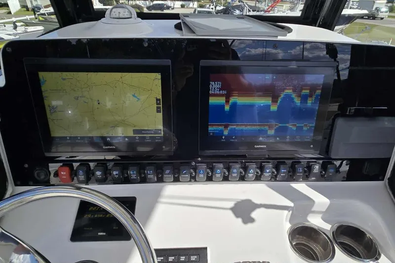 Slide: The Image of 2024 Sea Hunt Gamefish 27 Coffin Box dashboard with dual Garmin displays and controls. - 13