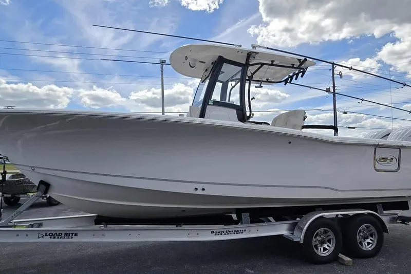 Slide: The Image of 2024 Sea Hunt Gamefish 27 Coffin Box boat on trailer under cloudy sky. - 4