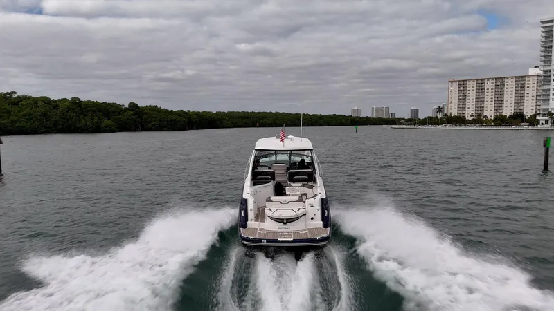 Slide: The Image of 2015 Monterey 335 Sport Yacht cruising on a waterway with cityscape in the background. - 18