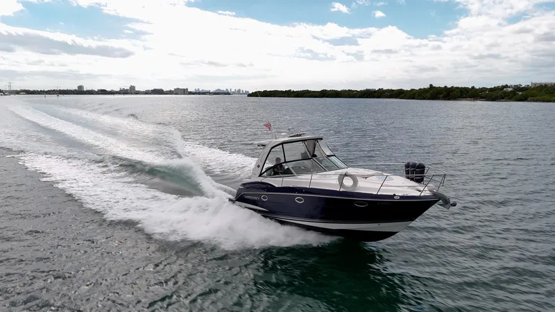 Slide: The Image of 2015 Monterey 335 Sport Yacht cruising on open water, creating a dynamic wake. - 20