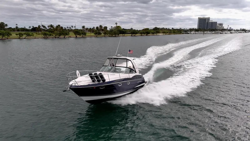 Slide: The Image of 2015 Monterey 335 Sport Yacht cruising on a scenic waterway under cloudy skies. - 23