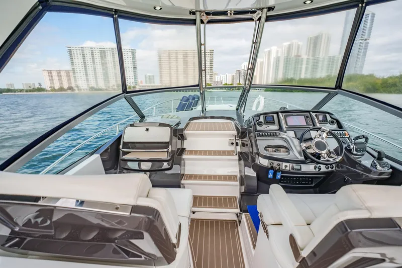 Slide: The Image of 2015 Monterey 335 Sport Yacht interior with modern dashboard, overlooking city skyline and water. - 26