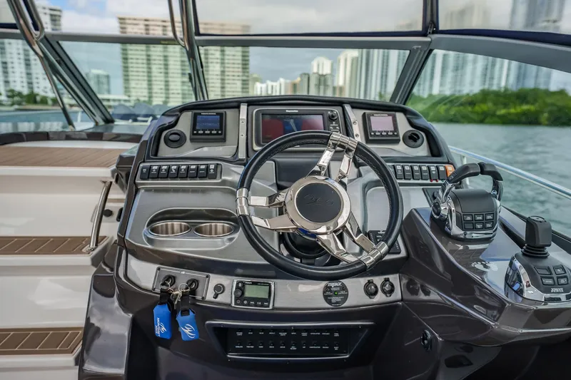 Slide: The Image of Helm of 2015 Monterey 335 Sport Yacht with modern controls and cityscape view. - 28