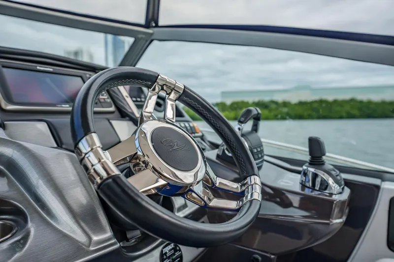Slide: The Image of Steering wheel of a 2015 Monterey 335 Sport Yacht, showcasing sleek design and controls. - 29