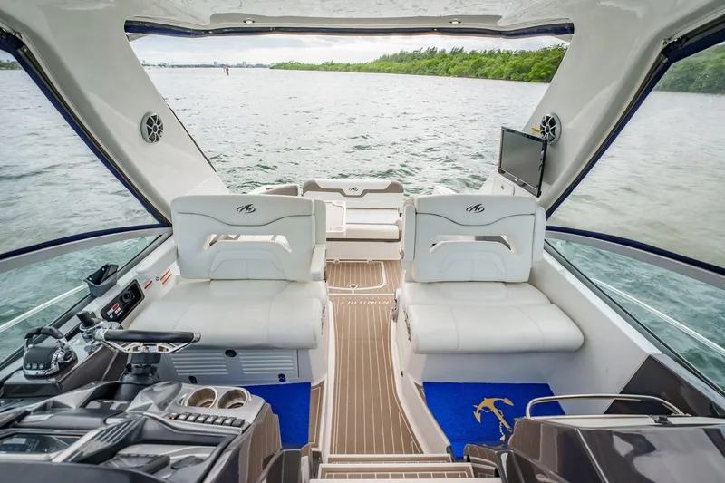 Slide: The Image of 2015 Monterey 335 Sport Yacht interior with white seating, wooden flooring, and water view. - 33