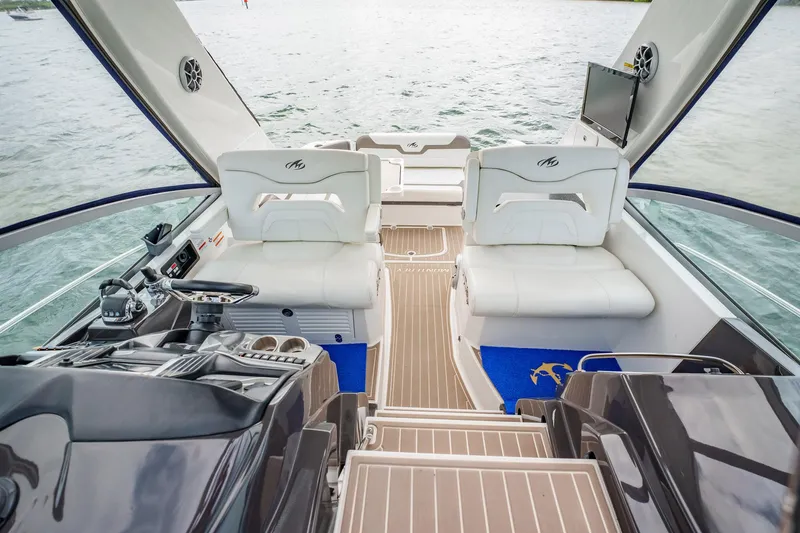 Slide: The Image of 2015 Monterey 335 Sport Yacht interior with luxurious seating and modern dashboard on open water. - 35