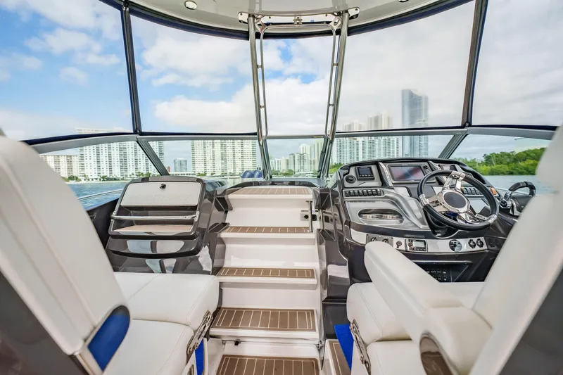 Slide: The Image of Interior view of 2015 Monterey 335 Sport Yacht with modern dashboard and cityscape background. - 37