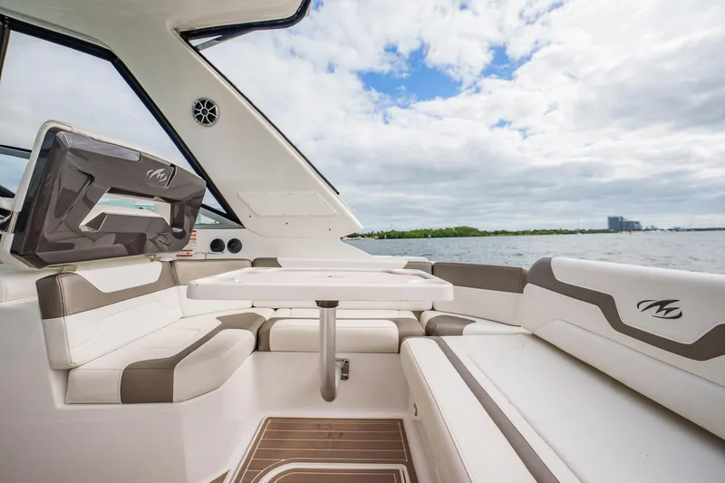Slide: The Image of 2015 Monterey 335 Sport Yacht interior with seating and table, overlooking water and sky. - 40