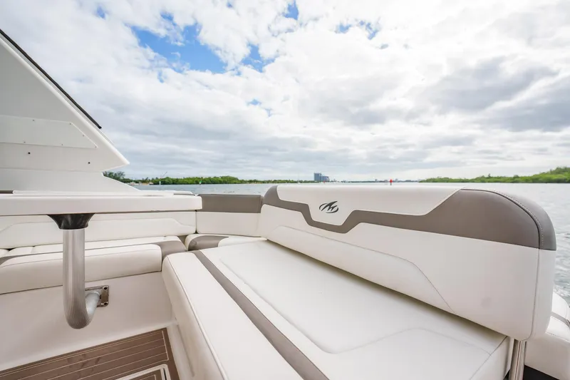 Slide: The Image of 2015 Monterey 335 Sport Yacht interior with white seating, under a partly cloudy sky. - 41