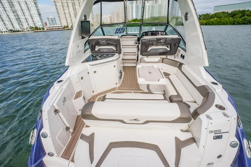 Slide: The Image of 2015 Monterey 335 Sport Yacht with spacious deck and seating, docked near cityscape. - 42