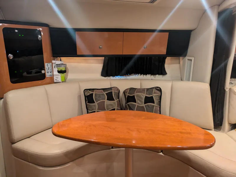 Slide: The Image of 2008 Chaparral 330 Signature yacht interior with beige seating and wooden table. - 11