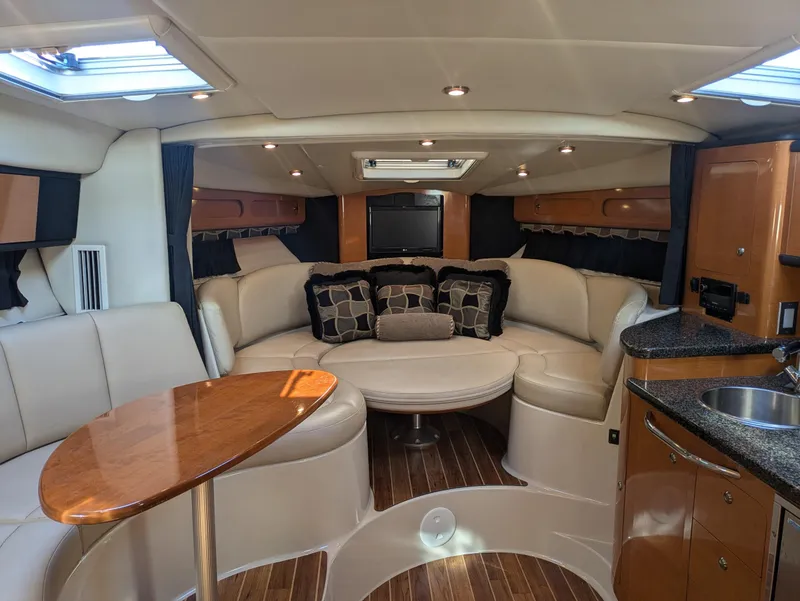Slide: The Image of 2008 Chaparral 330 Signature yacht interior with plush seating, wooden table, and modern amenities. - 13